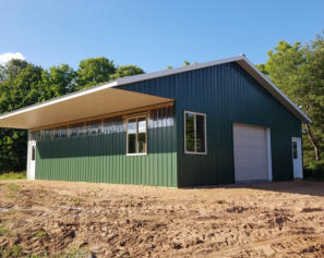 shed with overhang and green steel siding